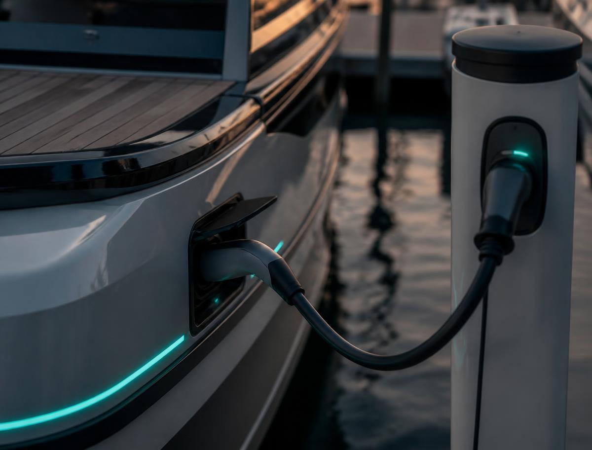 Electric boat plugged into a shore power pedestal at a marina slip